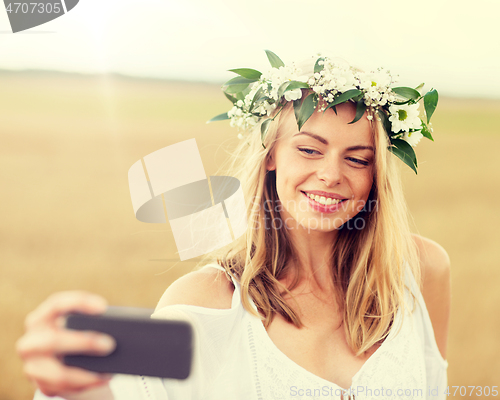 Image of happy young woman taking selfie by smartphone