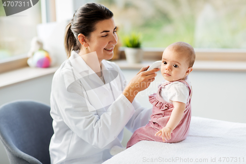 Image of doctor with thermometer measures baby temperature