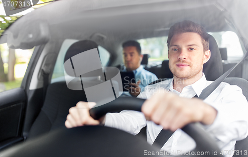 Image of male driver driving car with passenger