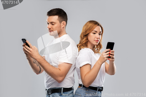 Image of couple in white t-shirts with smartphones