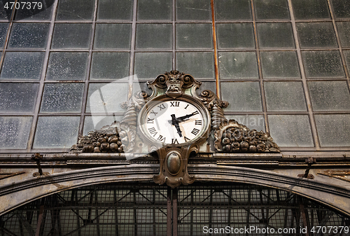 Image of Old clock hanging on ancient market wall. 