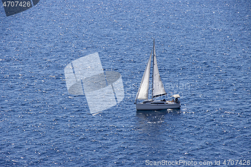 Image of Sailingboat with white sails at opened sea