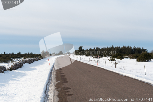 Image of Winding country road with snow stakes by roadside