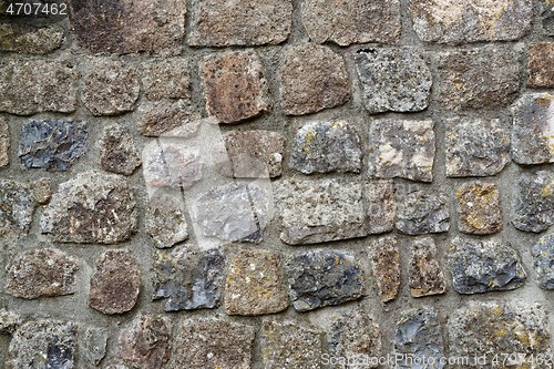 Image of Texture of gray stone wall covered with lichen