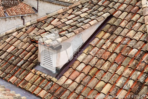 Image of An old tiled roof of a European house with a dormer