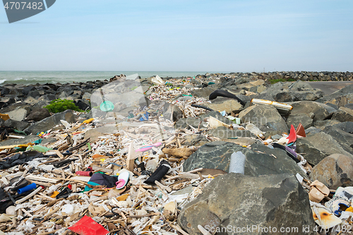 Image of Spilled garbage on the beach near the big city. Empty used dirty plastic bottles and other garbage. Environmental pollution. Ecological problem.