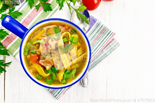 Image of Soup with mung and noodles in blue bowl on board top