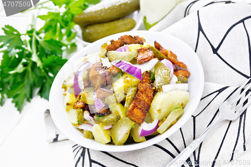 Image of Salad potato with bacon and cucumber in plate on towel