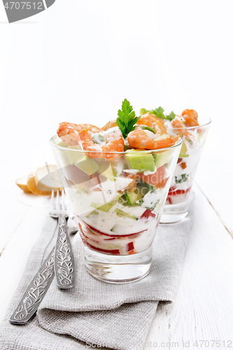 Image of Salad with shrimp and avocado in two glasses on napkin