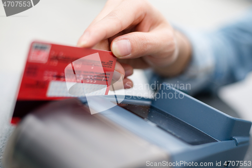 Image of Hand Swiping Credit Card In Store