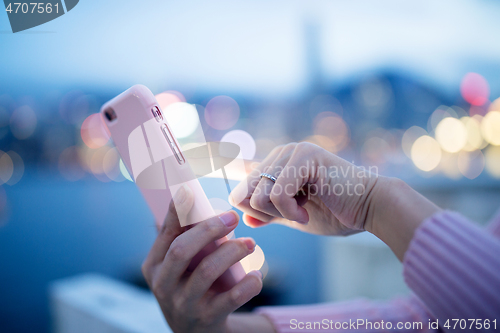 Image of Woman use of cellphone at night