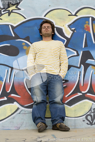 Image of Man next to a graffiti wall