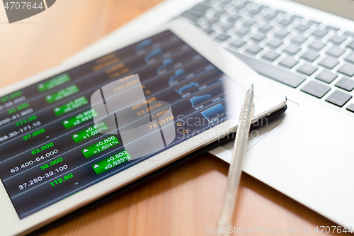 Image of Stock market graph with tablet pc and laptop