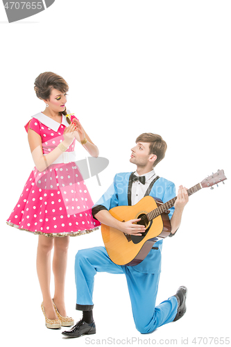 Image of doll looking boy and girl with guitar