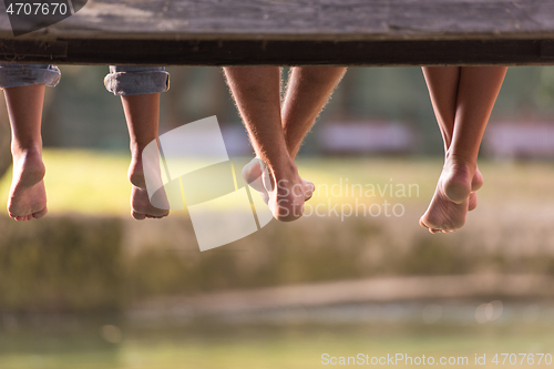 Image of people sitting at wooden bridge