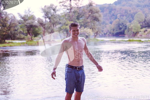 Image of man with a bare torso splashing water