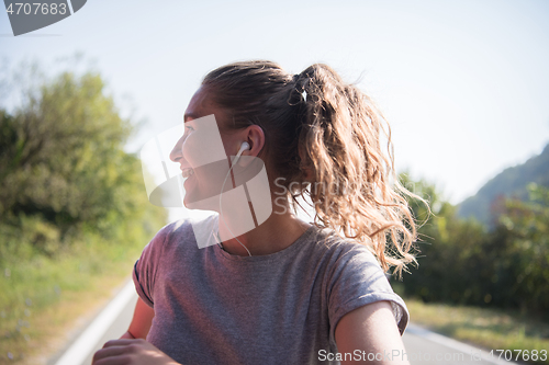 Image of woman jogging along a country road