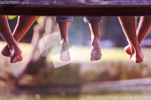 Image of people sitting at wooden bridge