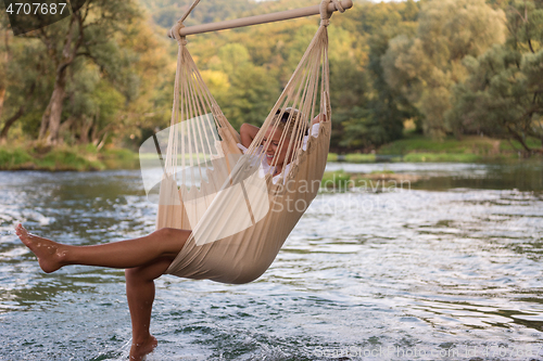 Image of blonde woman resting on hammock