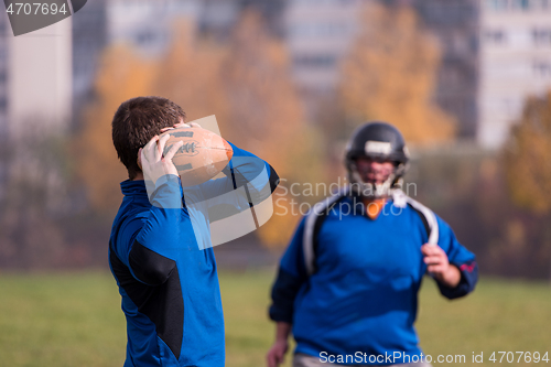 Image of american football team with coach in action