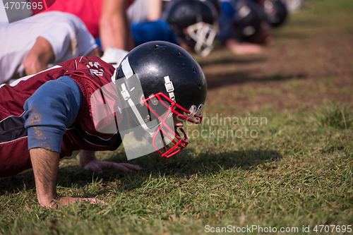 Image of american football team doing push ups