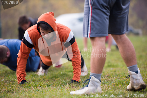 Image of american football team doing push ups