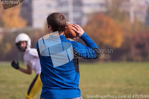 Image of american football team with coach in action