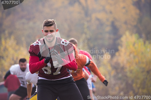 Image of american football players stretching and warming up