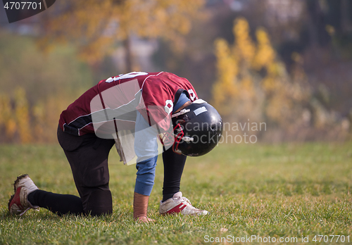 Image of american football player resting after hard training