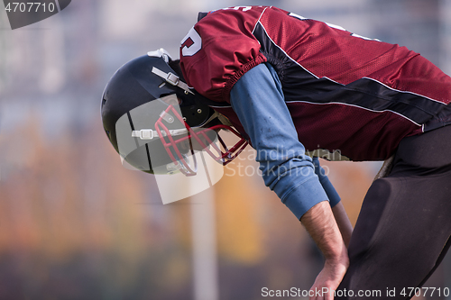 Image of american football player resting after hard training