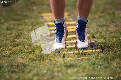 Image of american football player exercises on ladder drills