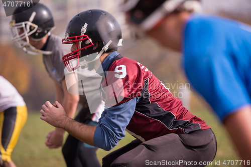 Image of american football players stretching and warming up