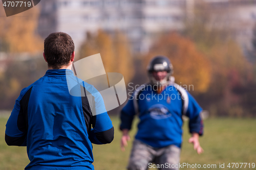 Image of american football team with coach in action