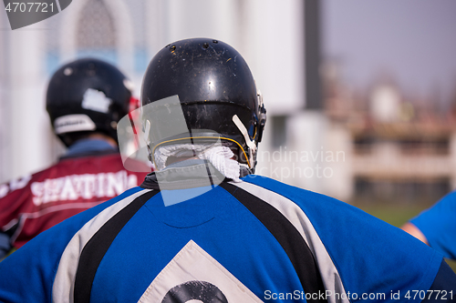 Image of american football team with coach in action