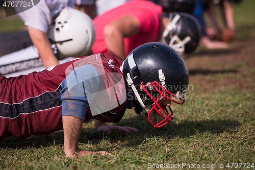 Image of american football team doing push ups