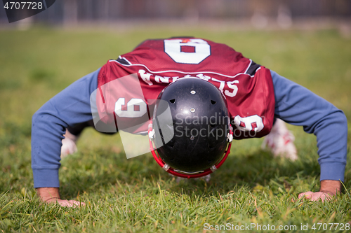 Image of american football player doing push ups