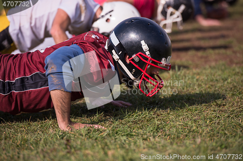 Image of american football team doing push ups