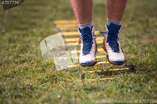 Image of american football player exercises on ladder drills