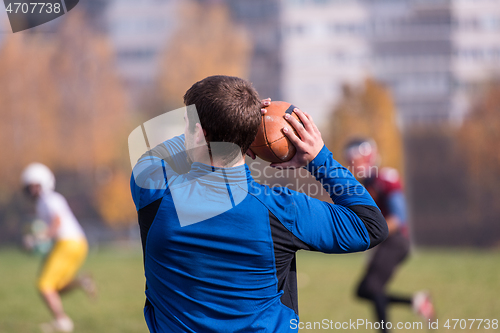 Image of american football team with coach in action