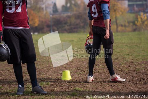 Image of American football player holding helmet