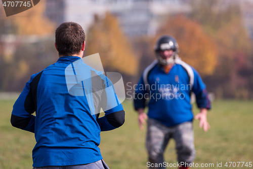 Image of american football team with coach in action