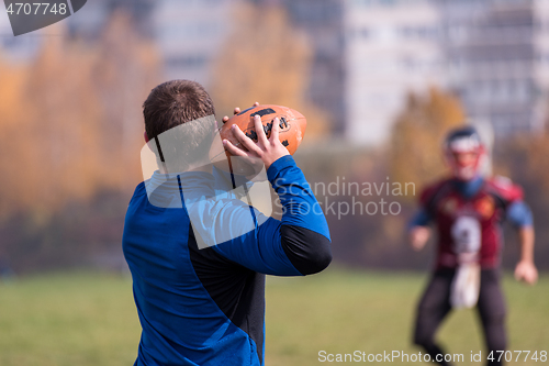 Image of american football team with coach in action