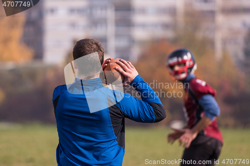 Image of american football team with coach in action