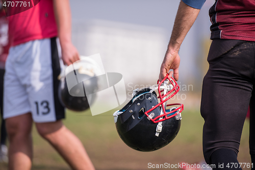 Image of American football player holding helmet