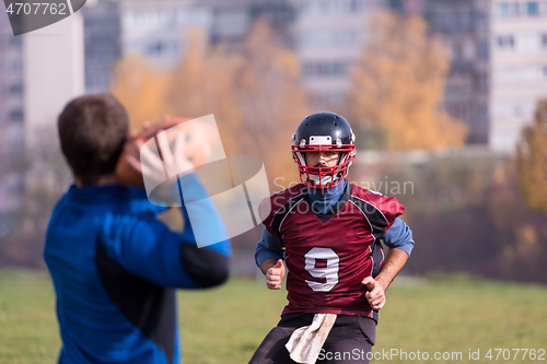 Image of american football team with coach in action