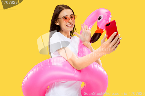 Image of Portrait of beautiful woman isolated on yellow studio background