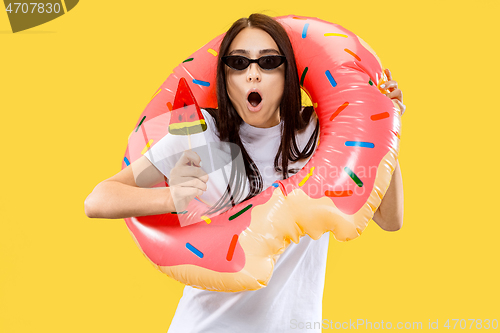 Image of Portrait of beautiful woman isolated on yellow studio background