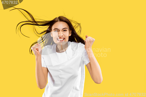 Image of Portrait of beautiful woman isolated on yellow studio background