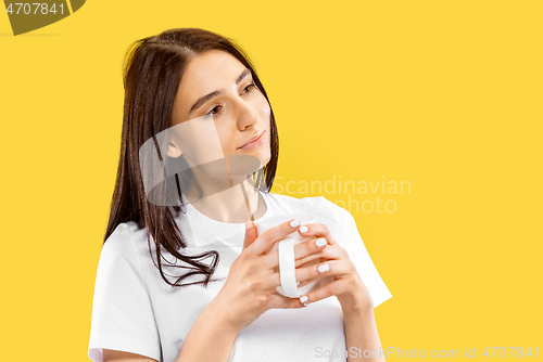 Image of Portrait of beautiful woman isolated on yellow studio background