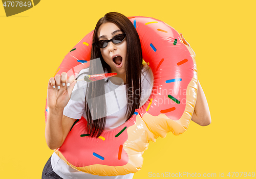 Image of Portrait of beautiful woman isolated on yellow studio background